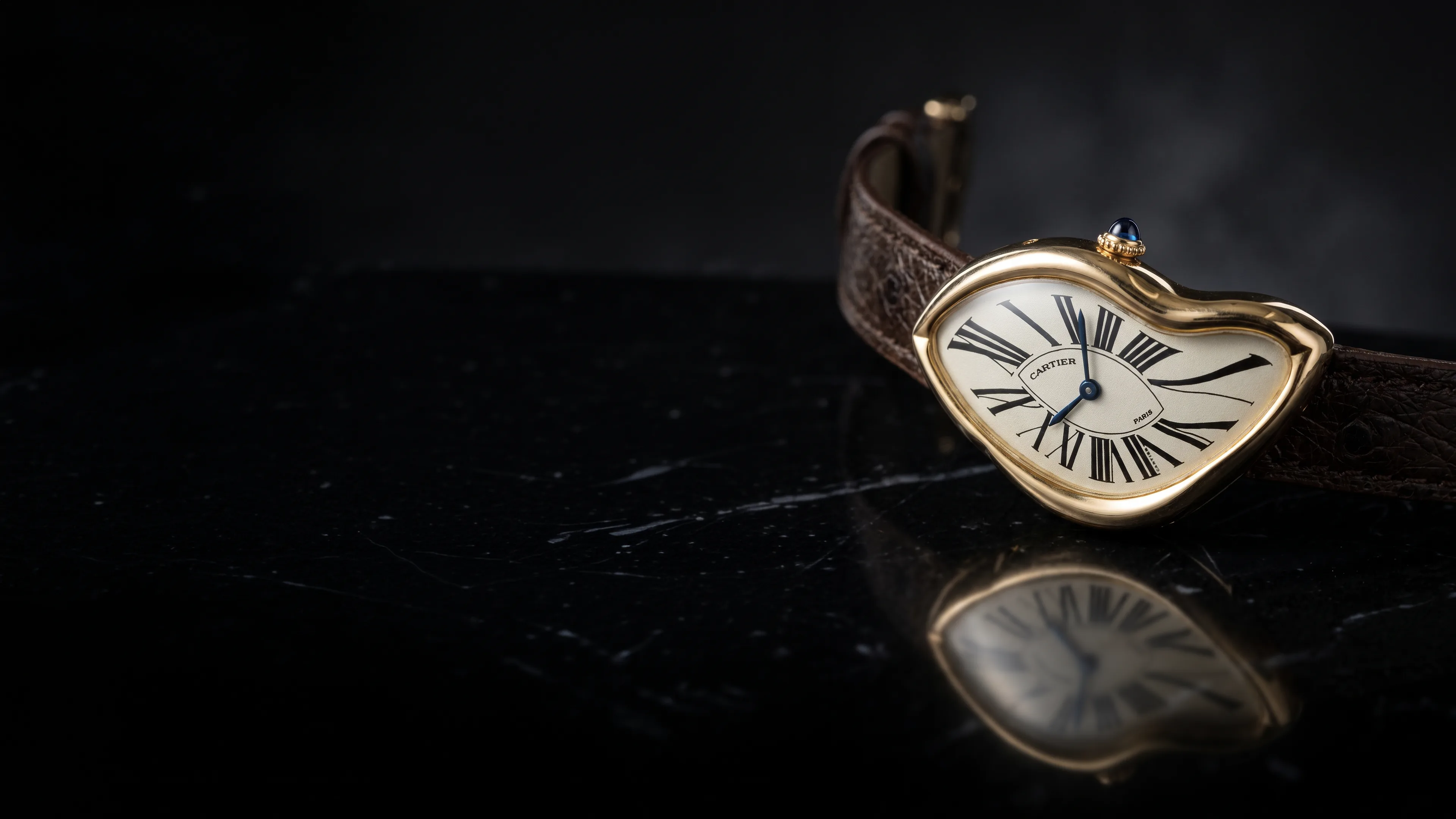 A Cartier Crash in yellow gold on black marble
